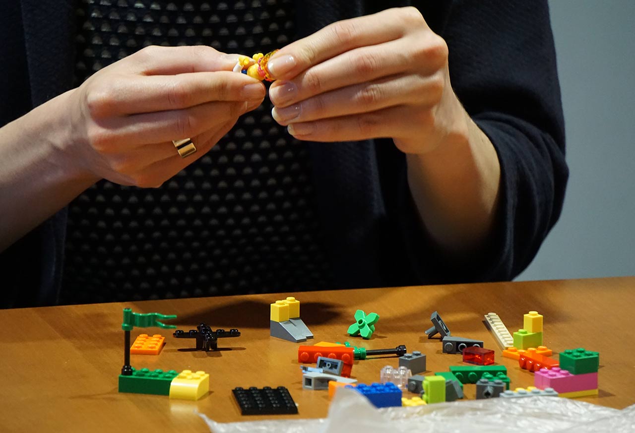Frau mit Lego Figur in den Händen
